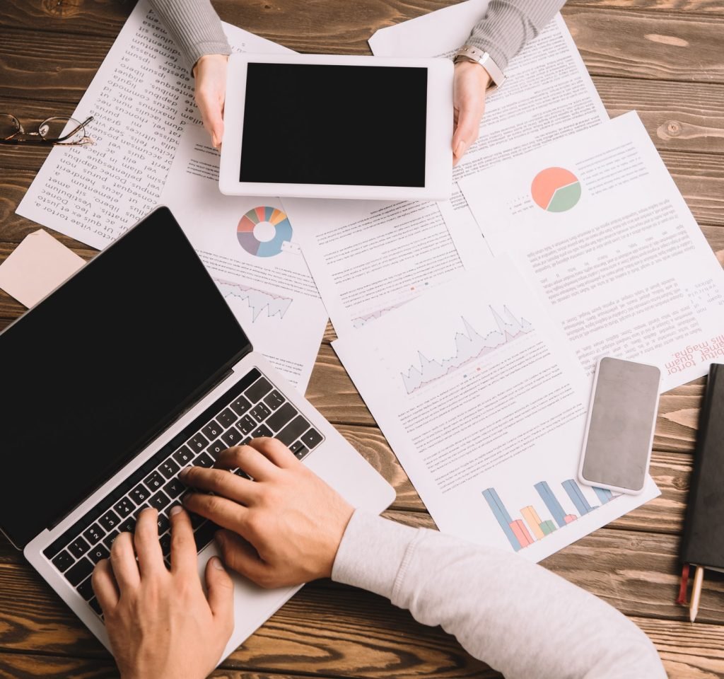 top view of businesspeople working with digital devices and documents.jpg